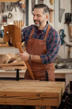 Tahtadan bir at her zaman için bir oyuncaktır. Marangoz bir planer bir atölyede vintage mobilya imalatı için çalışır. Torunu için tahta at yapar