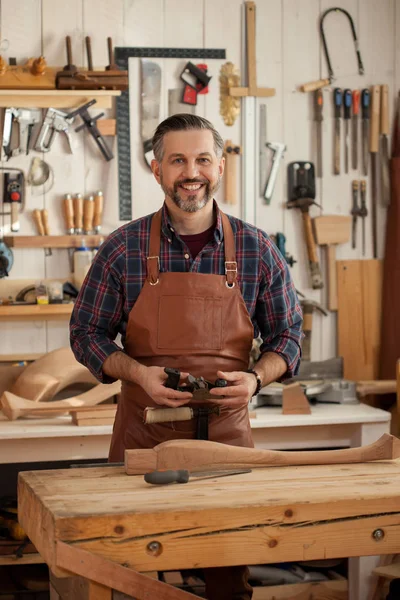 Mutlu marangoz. Orta Çağ yakışıklı marangoz cabriolet bacaklar ve gülümseyerek kameraya oluşturma işlemi bitti