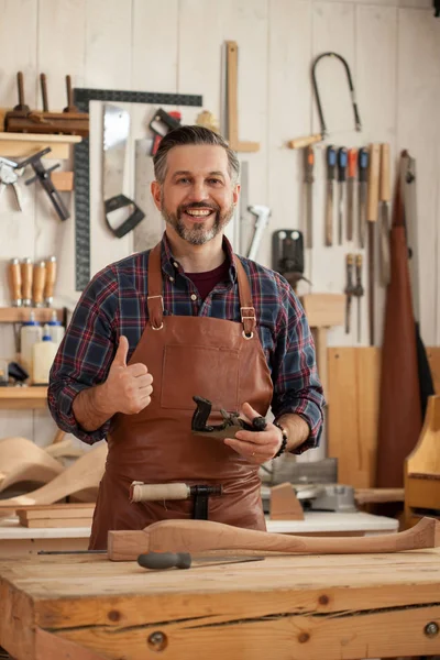 Mutlu marangoz. Orta Çağ yakışıklı marangoz cabriolet bacaklar ve gülümseyerek kameraya oluşturma işlemi bitti