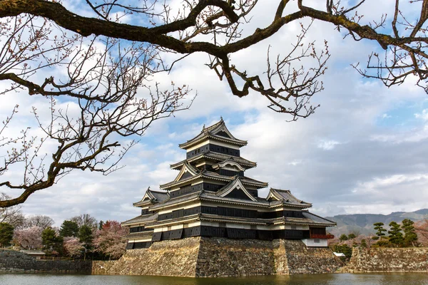 Castelo de Matsumoto na estação da mola cercada pela água sob clou — Fotografia de Stock