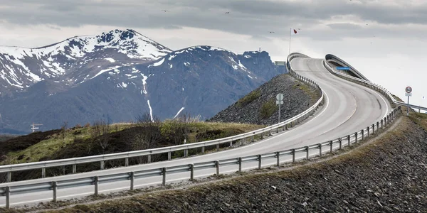 The bridge on the Atlantic Ocean Road with snow cap mountain ran — Stock Photo, Image