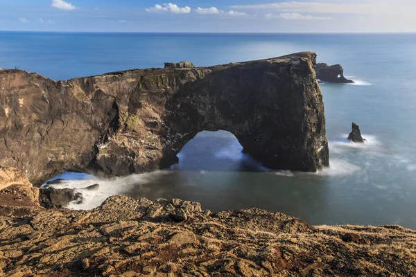 Длительное воздействие Dyrholaey Arch с гладкой водой — стоковое фото