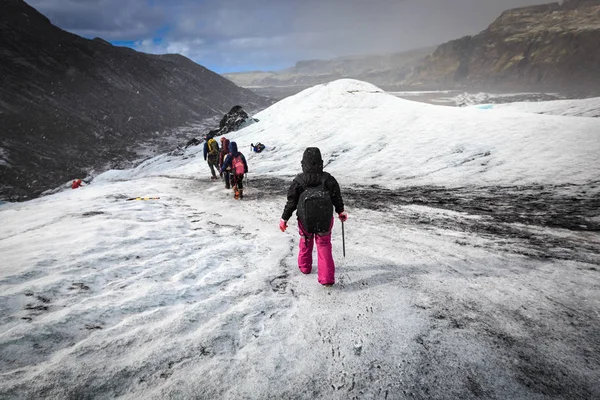 Grupo de caminhantes caminham no glaciar durante queda de neve pesada em Solheim — Fotografia de Stock