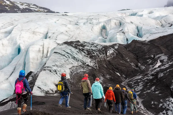 Gruppo di escursionisti a piedi sul ghiacciaio a Solheimajokull Fotografia Stock