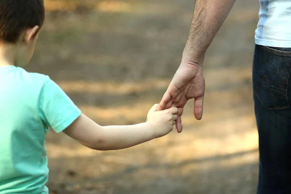 Le parent tient la main de son fils — Photo