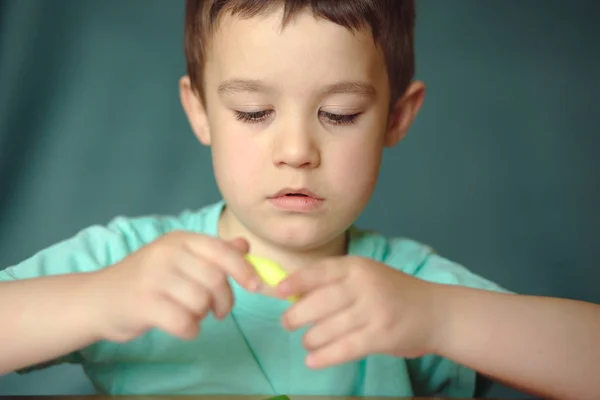 Jongen spelen met kleuren spelen deeg — Stockfoto