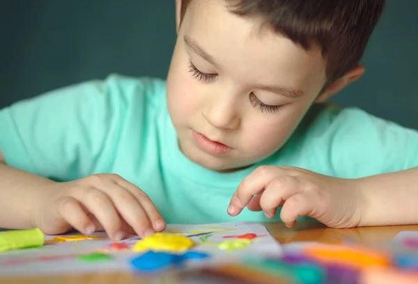 Jongen spelen met kleuren spelen deeg — Stockfoto