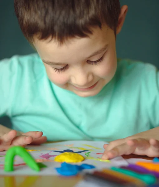 Chlapec hrát s barevné papírky — Stock fotografie