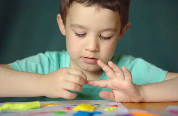 Jongen spelen met kleuren spelen deeg — Stockfoto