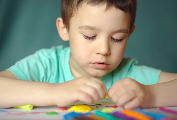 Chlapec hrát s barevné papírky — Stock fotografie