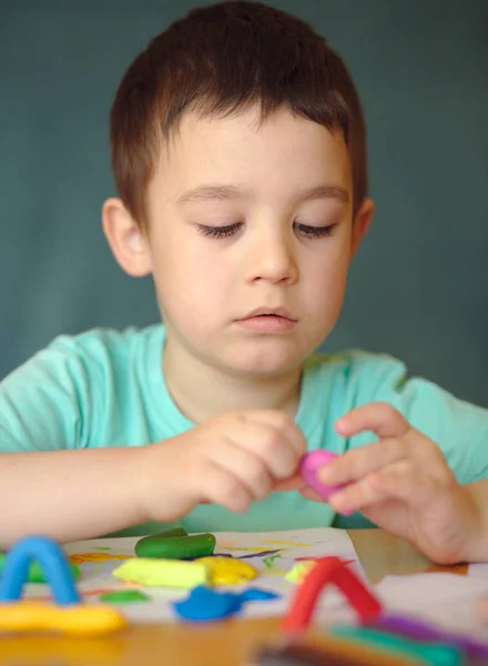 Junge spielt mit Farbspielteig — Stockfoto