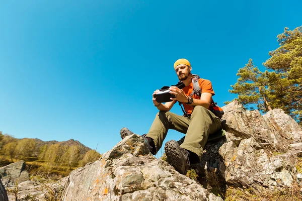 Successful young man, using virtual reality goggles to tour in mountains, on vacation in summer — Stock Photo, Image