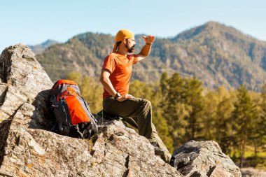 Sakallı genç erkek dağ, doğa görünümü, tadını çıkarırken rock tepede duran turist sırt çantası yoluyla seyahat dağlarda yaz tatili
