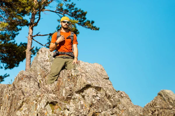 Sakallı genç erkek dağ, doğa görünümü, tadını çıkarırken rock tepede duran turist sırt çantası yoluyla seyahat dağlarda yaz tatili