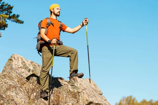Młody mężczyzna z brodą jest podróż przez góry, plecak turystyczny, stojąc na rock hill, rozkoszując się widokiem na okoliczną przyrodę, wakacje w górach — Zdjęcie stockowe
