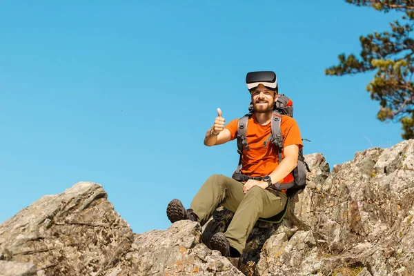 Jeune homme prospère, utilisant des lunettes de réalité virtuelle pour visiter les montagnes, en vacances en été — Photo