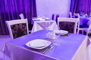 Kapalı tablo ile bir iç yeni lüks restoranda boş gözlük ve yemekleri ayarla