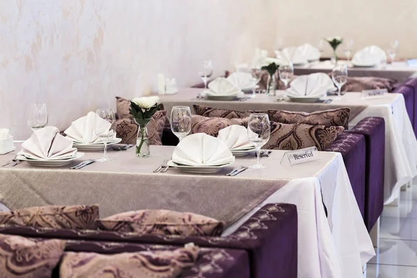 Verres et plats vides dans un nouveau restaurant de luxe intérieur avec tables couvertes — Photo