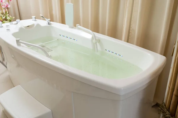 Leerer Whirlpool, mit Wasser gefüllte Badewanne im Wellnessbereich — Stockfoto