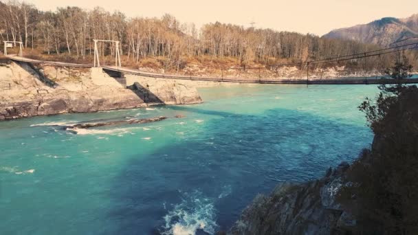 Панорама горная река, висячий мост, бирюзовая вода, лето и осень — стоковое видео