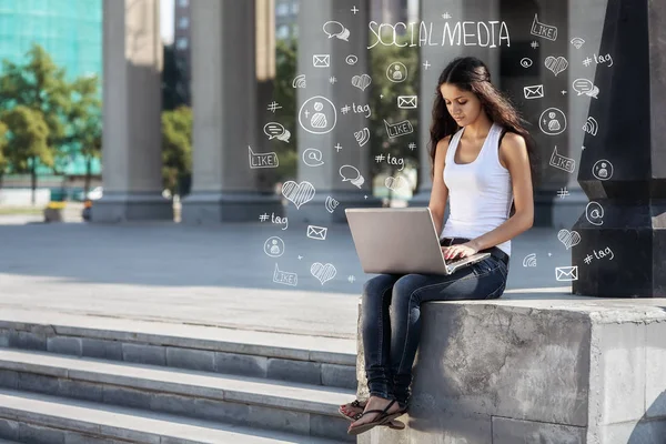 Young woman with laptop sitting on the stairs, near university — Stock Photo, Image
