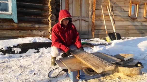 Young man repairing, circular saw, winter on the street, in the countryside — Stock Video