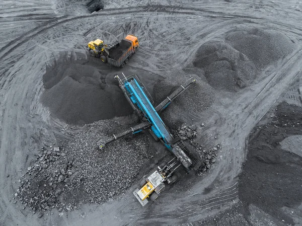 Открытая шахта, сортировка пород. Добыча угля. Бульдозер сортирует уголь. Добывающая промышленность, антрацит. Комплекс сокрушительного марширования. Угольная промышленность . — стоковое фото