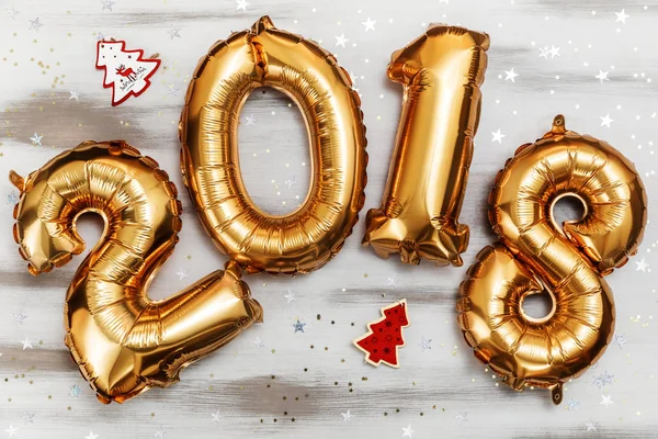 Jasne złota metalicznego balony figury 2018, Boże Narodzenie, nowy rok balon z brokat gwiazd na tle biały stół z drewna — Zdjęcie stockowe