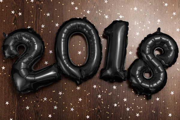 Jasne metalowe czarne balony figury 2018, Boże Narodzenie, nowy rok balon z brokat gwiazd na tle ciemnego drewna tabela — Zdjęcie stockowe