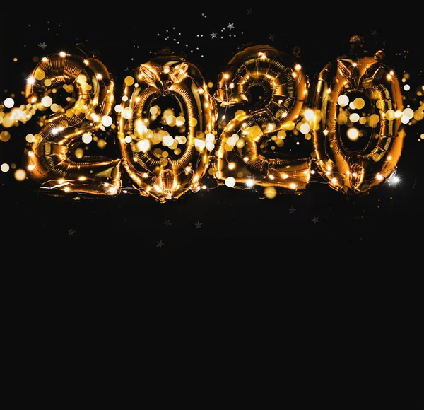 Bonne année 2020 célébration. Figures de ballons en or brillant, ballons du Nouvel An avec des étoiles scintillantes sur fond sombre. Noël et Nouvel An. Ballons dorés 2020 — Photo