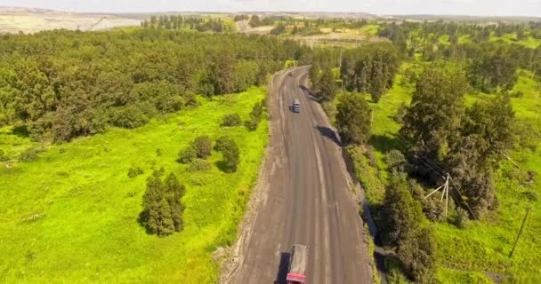 Luchtfoto van de truck. Met een draaibank bedekte vuilniswagen die kolen vervoert langs de landweg. Vrachtwagen rijdt op onverharde landweg. Truck rijdt langs een lege dorpsweg. Vrachtwagenlogistiek — Stockvideo