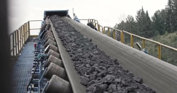 Courroie transporteuse avec tir au charbon au ralenti. Gros plan il y a du charbon sur le convoyeur à bande. Bande transporteuse charbon. Machine pour le chargement de l'exploitation minière dans une usine de charbon — Video