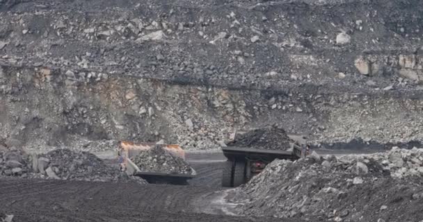 Kömür madenciliğinde büyük kamyonları yavaş çekimde vurmak ve taşımacılık üretimi. Kocaman bir çöp kamyonu kömür taşıyor. Açık maden ocağı. Taş taşıyan büyük bir çöp kamyonu. Madencilik endüstrisinde kömür işi — Stok video