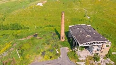 Köyün yakınlarında yıkılan binalar. Havadan ateş edildi. Yıkılmış binaların üzerinden uçmak. Tarlanın ortasında tuğla boruyla yıkılmış bir fabrika..