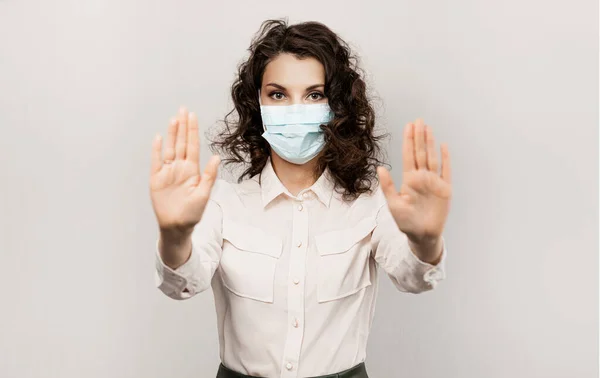 Gemaskerde vrouw stopt met handgebaar. Influencer Girl blogger in medisch masker praat over covid-19, coronavirus. Meisje met medisch masker stopt 2019-nCov — Stockfoto