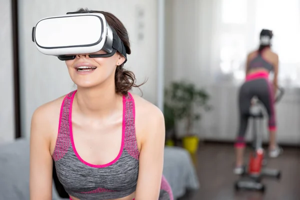 Young girl stay home in quarantine and go in for sports with virtual reality glasses. Woman exercise yoga while at home wearing virtual reality glasses