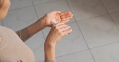 Karantina sırasında sıvı el dezenfektanı kullanan bir kadın. Virüse karşı ellerini temizlemek için alkol jeli kullanan bir kız, mikroplar. Genç bir kadın virüs koronavirüsünü önlemek için el dezenfektanı kullanıyor.
