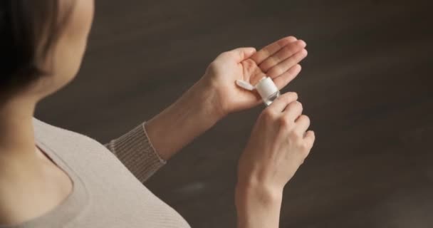 Femme utilisant un désinfectant liquide pour les mains pendant la quarantaine. Fille utilisant du gel d'alcool pour nettoyer les mains contre le virus, les germes. jeune femme utilisant un gel désinfectant pour les mains pour prévenir la propagation du coronavirus du virus, covid-19 — Video