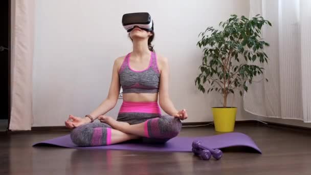 Menina ficar em casa em quarentena e ir para esportes com óculos de realidade virtual. Mulher ioga exercício enquanto em casa vestindo VR. Menina ficar em casa e envolvidos na aptidão em óculos de realidade virtual — Vídeo de Stock