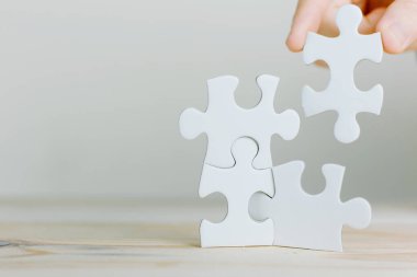 Yapboz 'u ışık efekti, iş çözümleri, başarı ve strateji konseptine bağlayan çalışan kadınların elleri