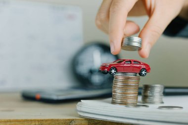 Emlak yatırımı ve araba ipoteği finansal konsepti, El para destesini ahşap eve koyuyor..