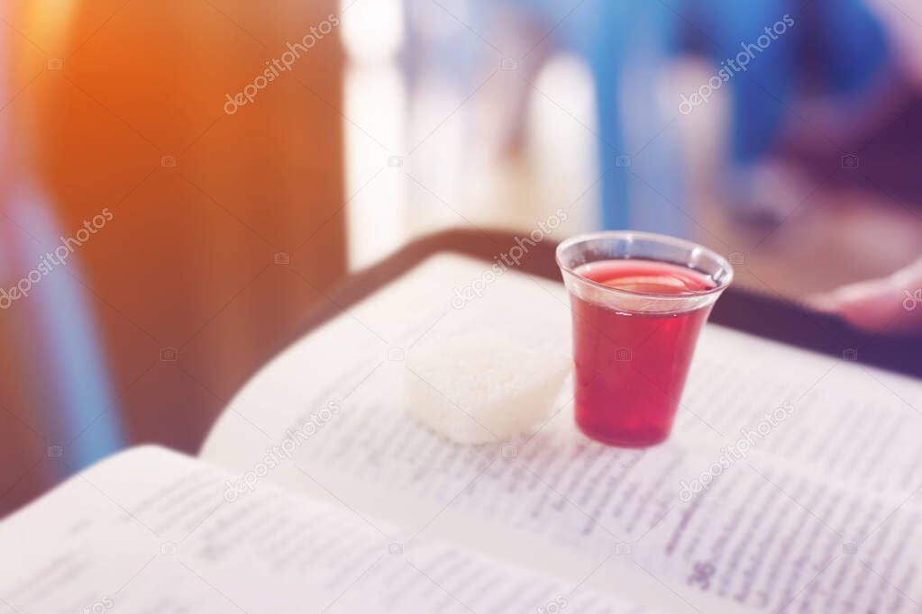 Hands hold a red wine cup in Holy communion