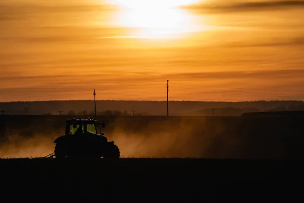 Traktor Sziluett Területen Narancs Sárga Naplemente — Stock Fotó