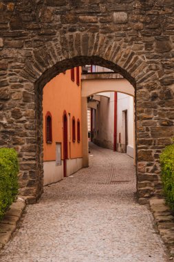 Ortaçağ kasabasının yakınındaki, dolambaçlı ve renkli evleri olan güzel taş kapı..