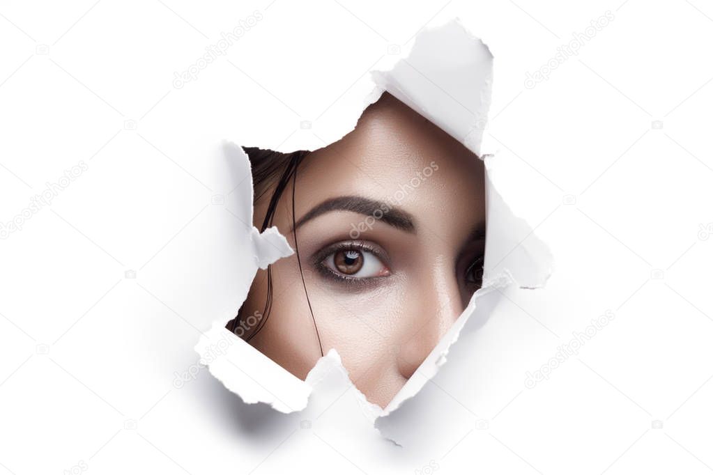 Woman Looking Through Ripped Paper Hole