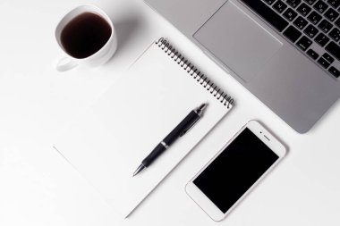 Fincan kahve, defter ile kalem ve Laptop yakınındaki Smartphone ile