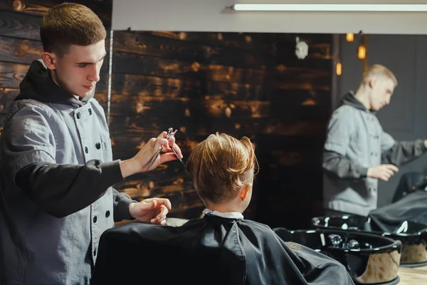 Pequeño chico consiguiendo corte de pelo por barbero — Foto de Stock