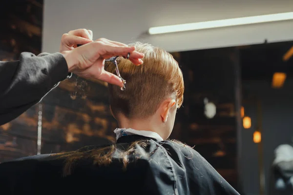 Маленький мальчик стрижется парикмахером — стоковое фото