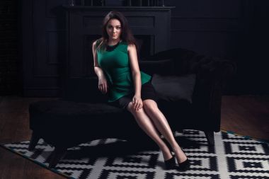 Siyah iç kanepede oturan genç güzel kadın