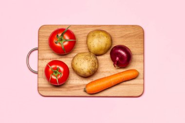 Patates, mor soğan ve havuç yakınındaki iki taze domates